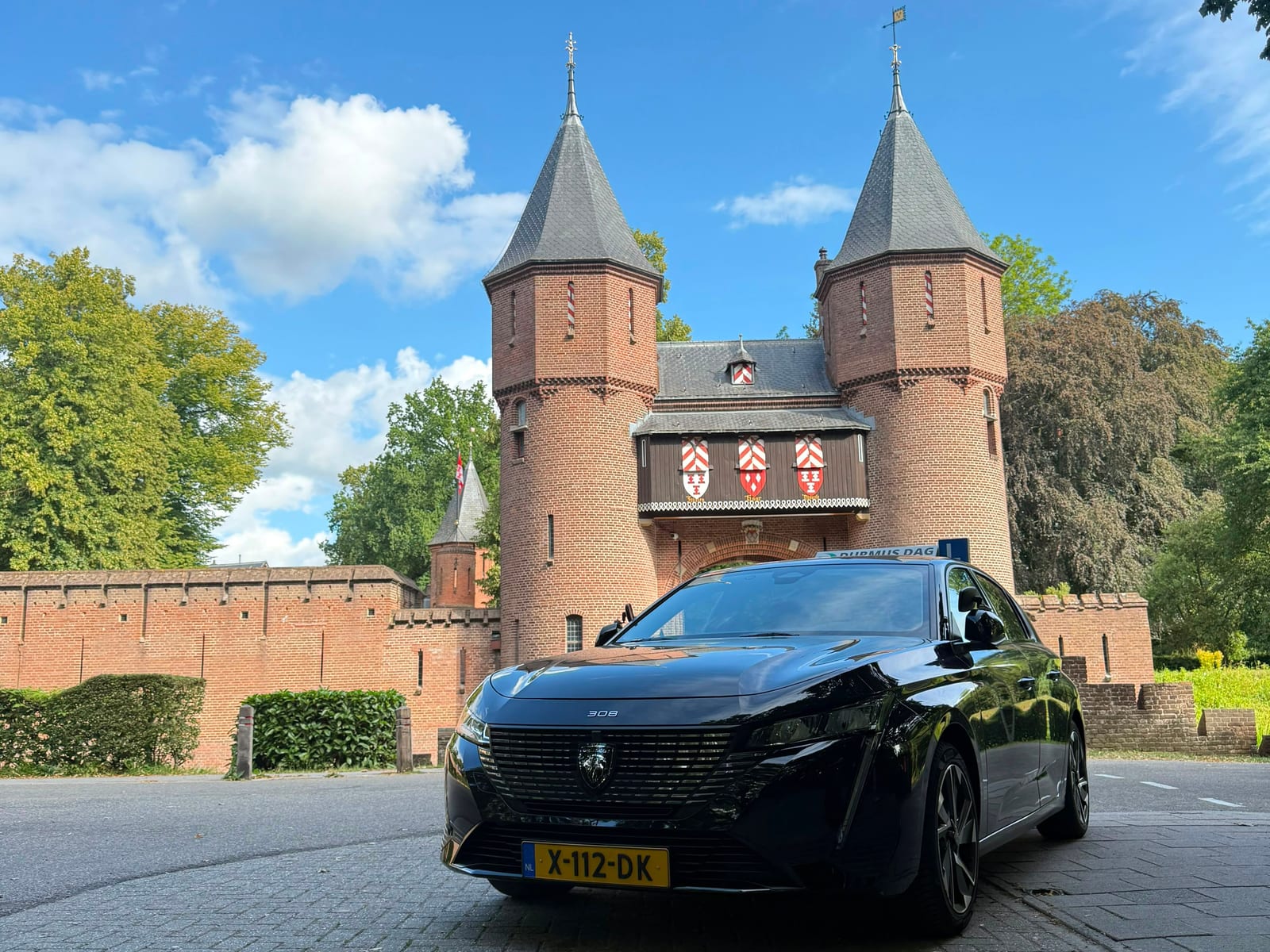 De zwarte Peugeot-lesauto van Durmus Dag voor het poortgebouw van Kasteel de Haar
